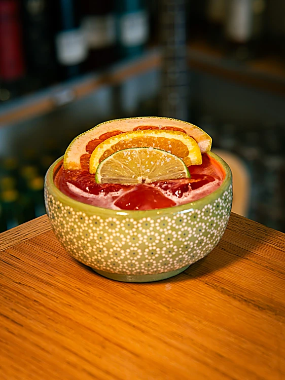 Cazuelita Tlaquepaque en cazuela de barro verde, con rodajas de naranja, toronja y limón